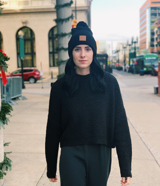 young woman with black beanie hat and black sweatshirt