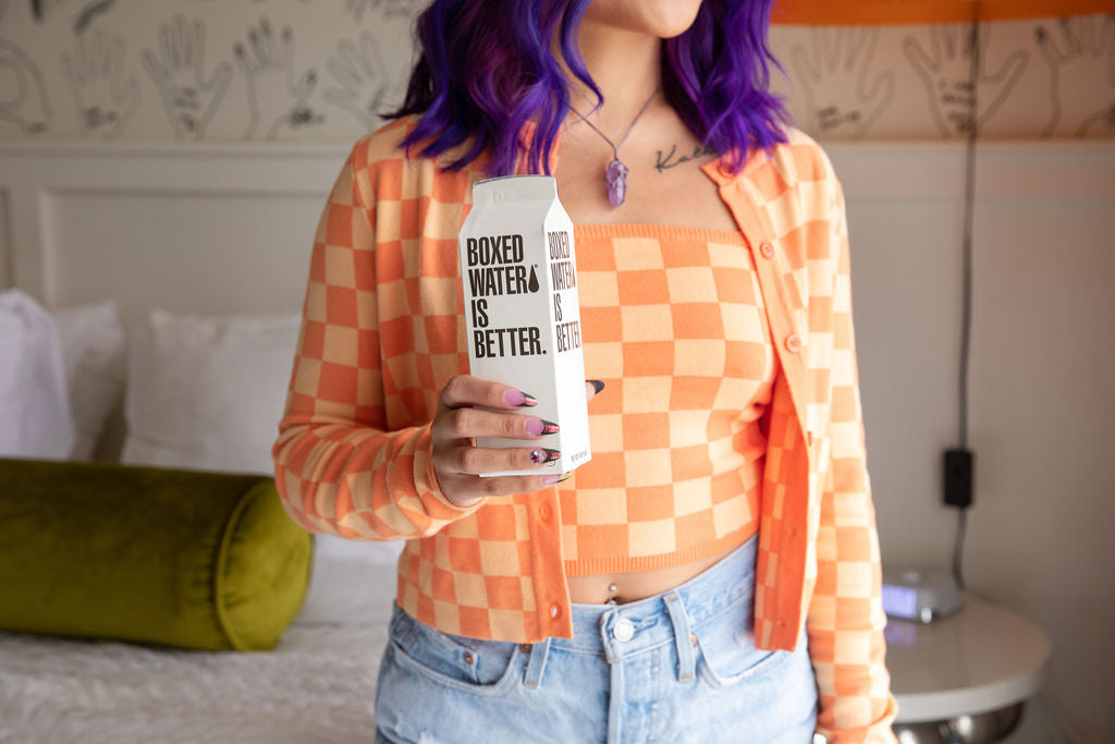 Woman holding Boxed Water carton