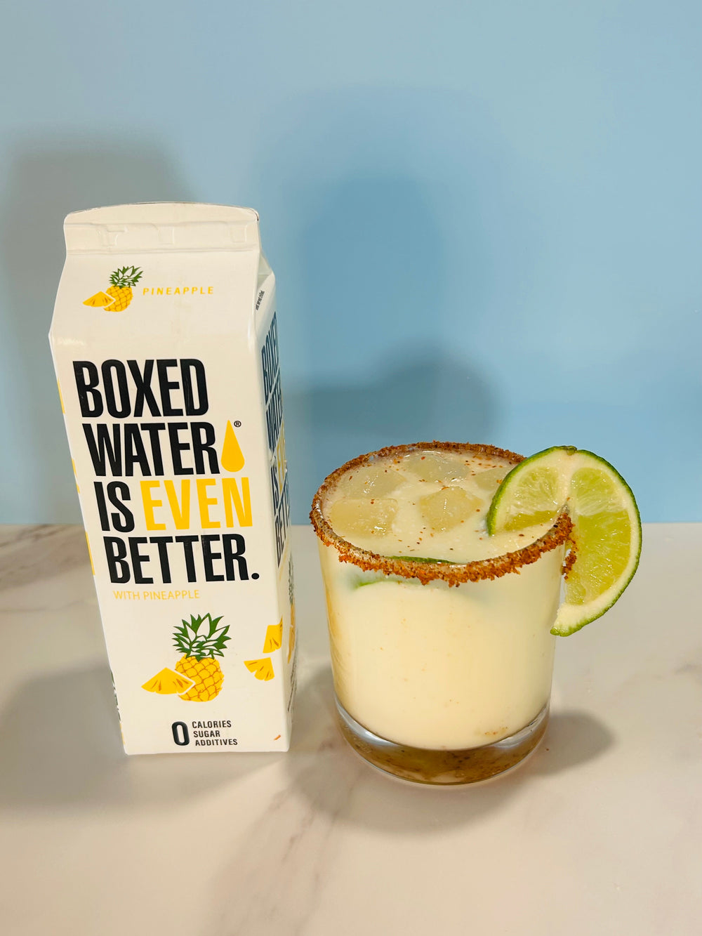 pineapple boxed water and coconut drink on blue background