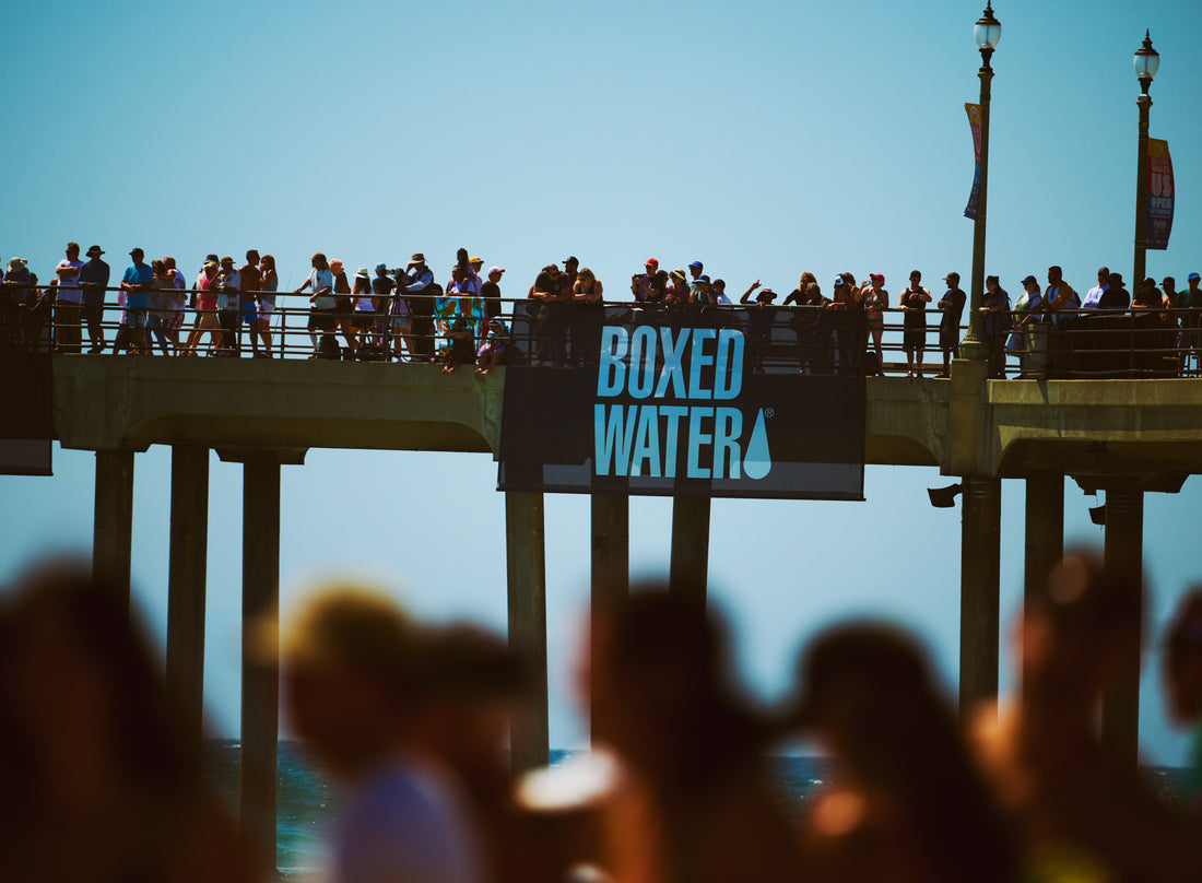 Crowd holding a Boxed Water banner