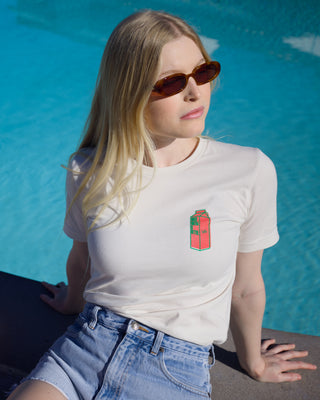 Girl wearing Boxed Water Watermelon flavored carton on a t-shirt sitting next to a pool