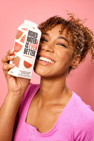 Woman smiling with Boxed Water Watermelon flavor