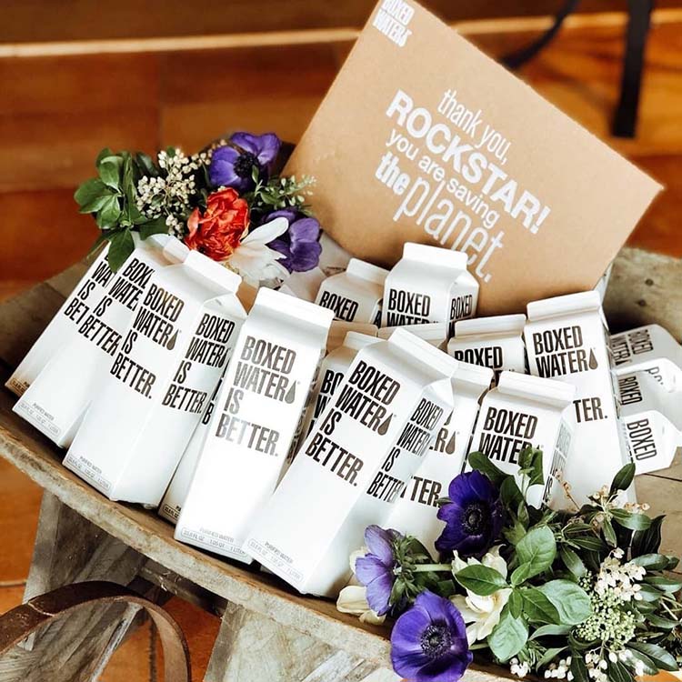 Many boxed water cartons in a bucket with flowers