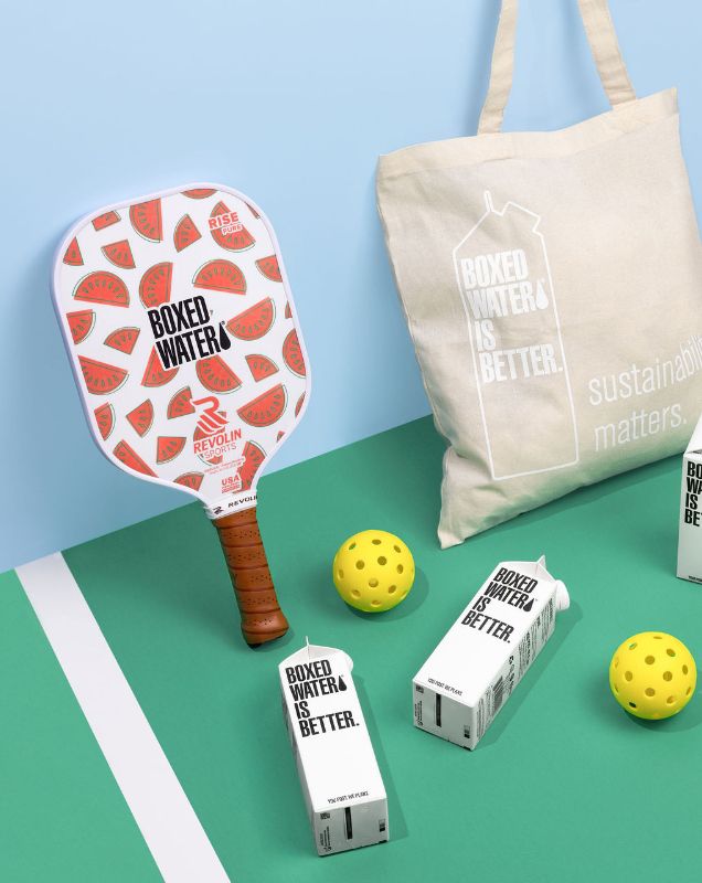 Watermelon pickleball racket with balls, boxed water and a boxed water tote