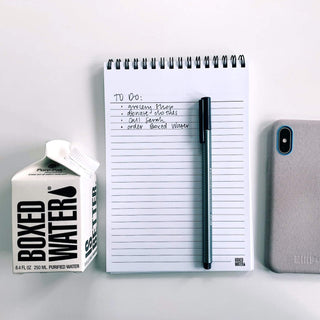 Boxed Water Carton next to notepad, pen and cell phone with a To-Do List