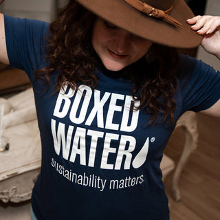 female wearing Boxed Water Sustainability Matters t-shirt wearing brown hat